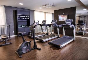 a gym with treadmills and elliptical machines at Sofistic Hotel in Itapema +66 photos
