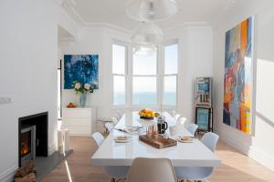 a white dining room with a white table and chairs at Big Luxury House sleeps 12/14. Sea Views, Hot tub. in Hollington