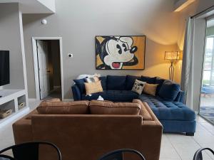 a living room with a blue couch and a tv at Its A Dream Family Vacation Rental - Minutes from Disney in Kissimmee