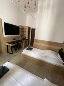 sypialnia z 2 łóżkami i biurkiem z telewizorem w obiekcie Aparthotel Łódź 55 Piotrkowska w Łodzi