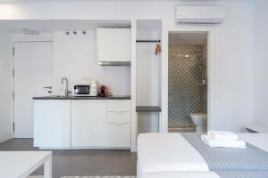 a white kitchen with a bed and a sink at Apartamentos Dolium in Seville +54 photos