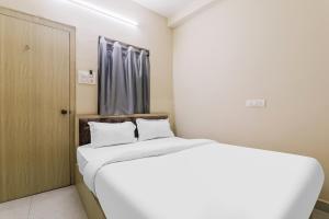 ein Schlafzimmer mit einem großen weißen Bett und einem Fenster in der Unterkunft Super OYO Hotel Rameshwar in Ranchi