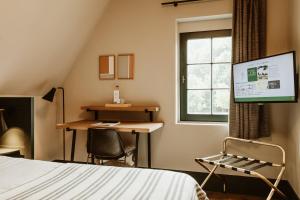 a bedroom with a bed and a desk and a window at Auberge du Pêcheur in Sint-Martens-Latem