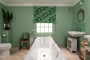 a bathroom with a tub and a toilet and a window at Abbey Mews in Bath