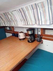 una macchinetta del caffè in cima a un tavolo in legno su una barca di Voilier Love Menton a Mentone