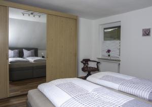 a bedroom with two beds and a window at Weinstube Ferienwohnungen Johann Benzschawel in Irsch