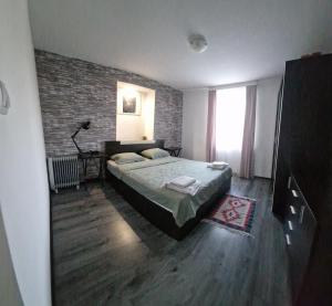 - une chambre avec un lit et un mur en briques dans l'établissement Къща за гости Casa Blanca, à Targovichté