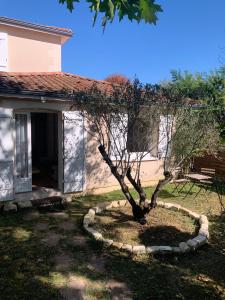 a tree in a circle in front of a house at Beau T2 meublé récent in Bouliac