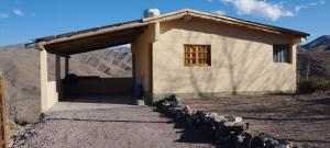 ein kleines Gebäude mit einer Tür und einem Fenster in der Unterkunft La Nave 2 in Potrerillos