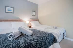 Un dormitorio con dos camas y una almohada sobre una cama. en 17 Beach Court - 2 Bed Apartment - Saundersfoot, en Saundersfoot