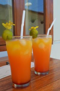 two glasses of orange juice on a wooden table at El Taraw Bed & Breakfast in Puerto Princesa City