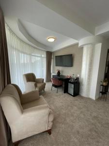 een woonkamer met 2 stoelen en een bureau in een kamer bij Complex Turistic Darina Sancraiu de Mures in Sîncraiu de Mureş
