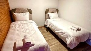 a room with two beds with white sheets and towels at Mira Deluxe Bungalov in Sapanca