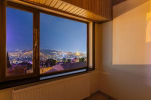 una camera con una grande finestra con vista sulla città di Apartments with wine cellar in Old Tbilisi a Tbilisi City
