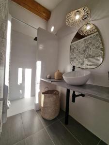 Maison de famille في Bouillargues: حمام مع حوض ومرآة