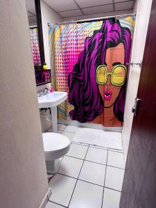 une salle de bain avec un rideau de douche avec une femme à lunettes dans l'établissement Condado Beachfront Tantra Apartment, à San Juan