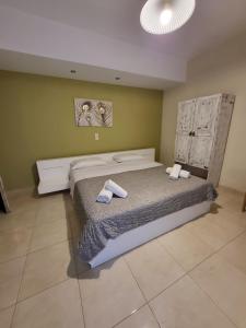 een slaapkamer met een bed met twee handdoeken erop bij Panorama Hotel - Restaurant in Diakopto