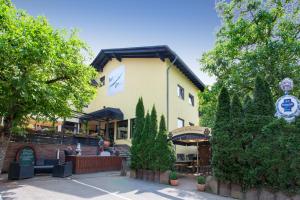 un gran edificio amarillo con un restaurante delante de él en Hotel Waldesruh en Mühltal