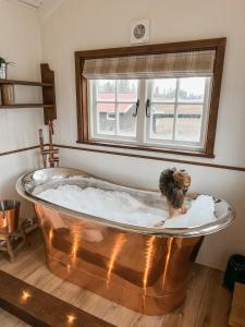 WonderInn Riverside في Årnes: امرأة في حوض استحمام في غرفة