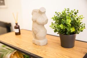 a statue of a woman sitting on a table next to a plant at Gaia Studio House in Budapest