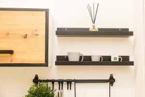 a shelf on a wall with two cups on it at Gaia Studio House in Budapest