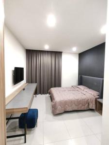 Schlafzimmer mit einem Bett, einem Schreibtisch und einem TV in der Unterkunft Kuching Near SGH Kozi Square Apartment 4 in Kuching