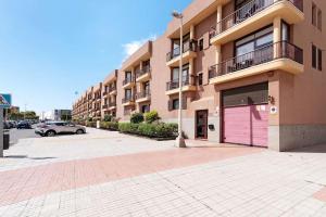 a building with a pink garage in a parking lot at Mar y Sol Salinetas in Telde