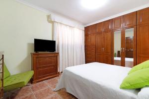 a bedroom with a bed and a flat screen tv at Mar y Sol Salinetas in Telde