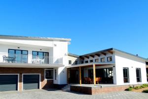 a white house with a porch and a balcony at 14 at Karee in Stilbaai