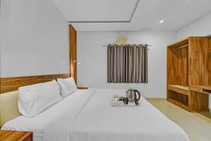 een slaapkamer met een wit bed en een telefoon. bij OYO Townhouse 801 The Circle in Jaipur