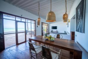 a dining room with a table and a view of the ocean at Beachfront Turtle House ZanzibarHouses in Kiwengwa