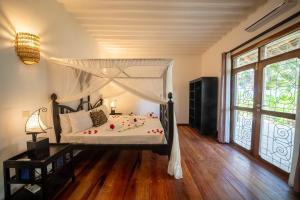 1 dormitorio con 1 cama con dosel en Beachfront Turtle House ZanzibarHouses en Kiwengwa