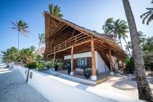 a resort on the beach with palm trees at Beachfront Turtle House with Private Pool ZanzibarHouses in Kiwengwa