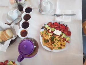 a table with a plate of food and a plate of bread at Vila Livio - Guest house Rreshen Mirdite in Rrëshen