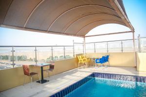 فندق ارين البساتين  في جدة: مسبح وكراسي وطاولة