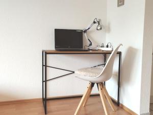 un escritorio con una silla y un ordenador. en Cozy home - Willkommen in Aachen - Boxspringbett - Balkon 