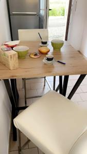 - une table en bois avec des bols dans la cuisine dans l'établissement Duplex Le Chant des Oiseaux, à Abbeville