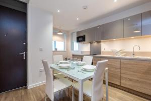a kitchen and dining room with a table and chairs at Divine Suite in London