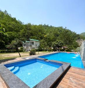 a large swimming pool in a yard with a house at Aspen Adventures Camp by Aspen in Rishīkesh