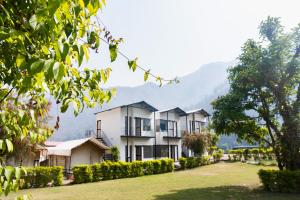 a row of houses with mountains in the background at Aspen Adventures Camp by Aspen in Rishīkesh