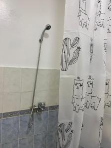 a shower curtain with cats drawn on it in a bathroom at Résidence Martil Deluxe in Martil