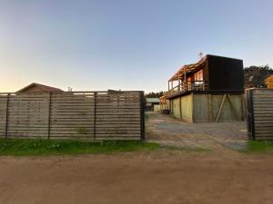 een boerderij met een hek en een huis bij Cabaña Estudio - BBQ Cocina Estacionamiento Wifi in Quintay