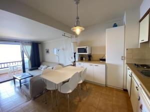 een keuken en een woonkamer met een tafel en stoelen bij Maravilloso apartamento PRIMERA LINEA DE MAR in L'Escala