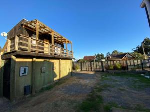 een gebouw met een balkon aan de zijkant bij Cabaña Estudio - BBQ Cocina Estacionamiento Wifi in Quintay +14 foto's