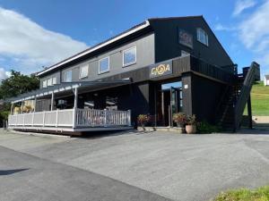 a black building with a staircase in a parking lot at Gjøa Motell in Rosendal