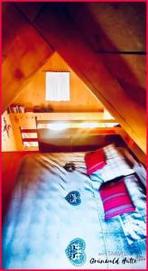 uma cama com almofadas vermelhas em Grünwald Hütte em Tarvisio