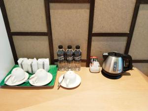Southern Airport Hatyai في هات ياي: طاولة مع مجموعة الشاي وقدر القهوة