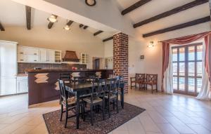 une grande cuisine avec une table et des chaises noires dans l'établissement Villa Baldasera, à Vižinada