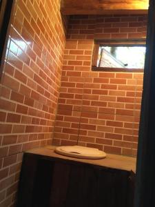 uma casa de banho com um WC numa parede de tijolos em Orgânica-Mente B&B em Viscode de Mauá