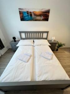 - un lit avec des draps et des oreillers blancs dans l'établissement Gesamte Unterkunft für 4 Top 18, à Vienne